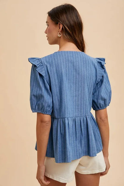Denim peplum blouse by Annie Wear with stripe front bow, styled with long sleeves and a fitted silhouette.