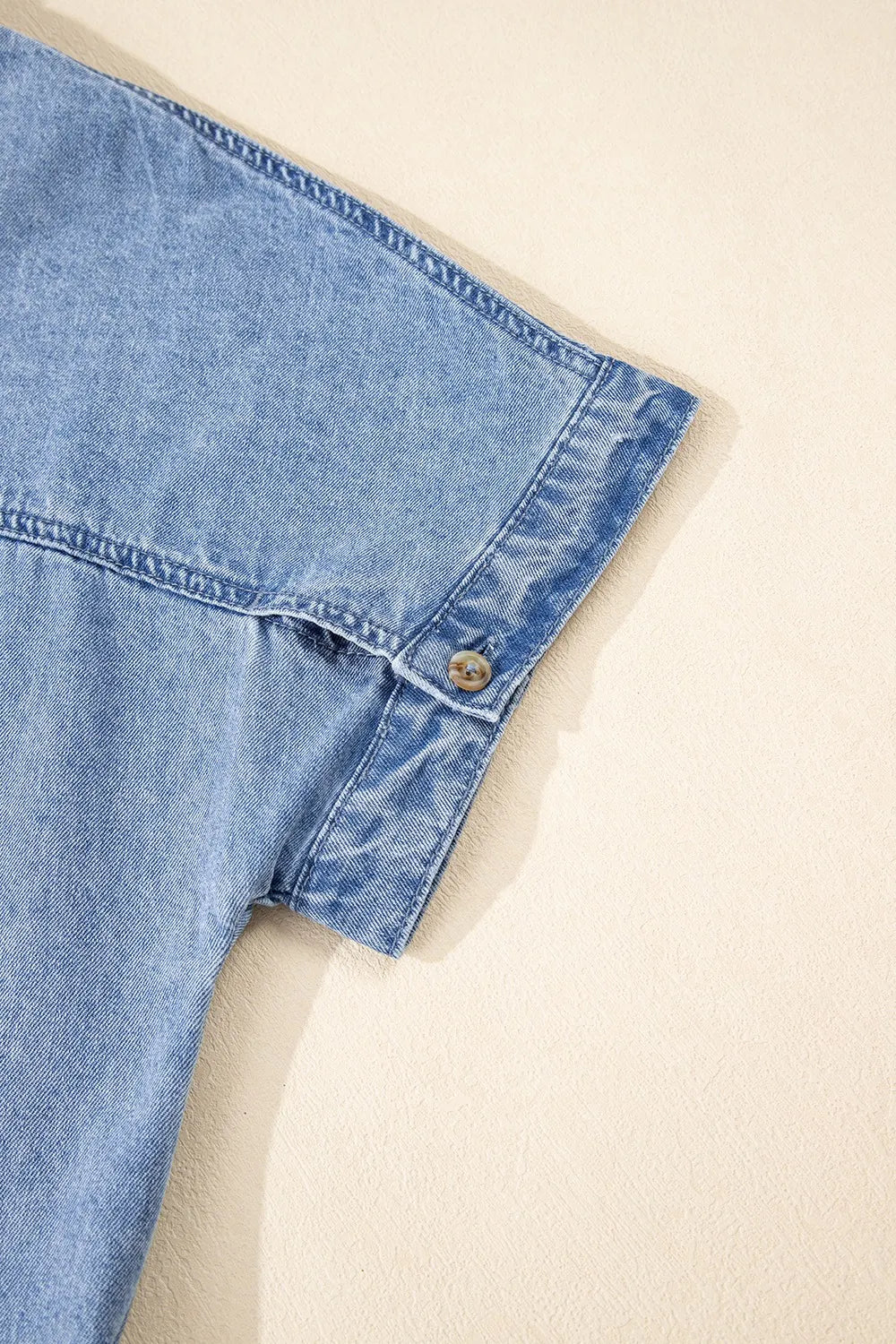Medium-length denim dress by Trendsi featuring a button-down front and short sleeves, styled for casual wear.
