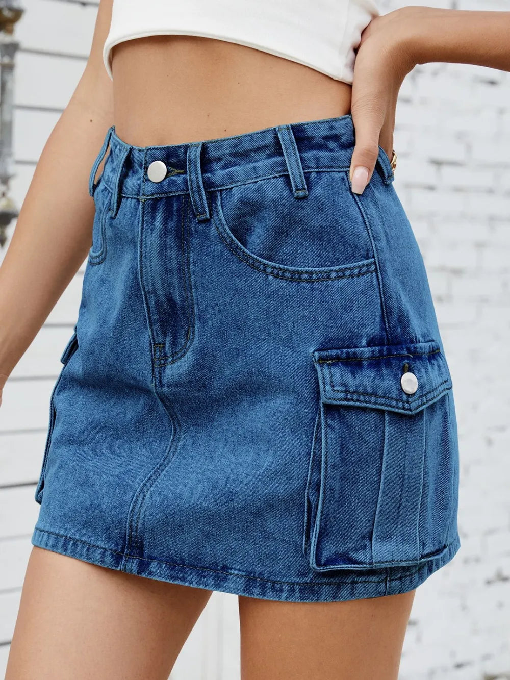 Medium-length trendy cargo denim skirt by Trendsi, featuring multiple pockets and a casual, stylish design.