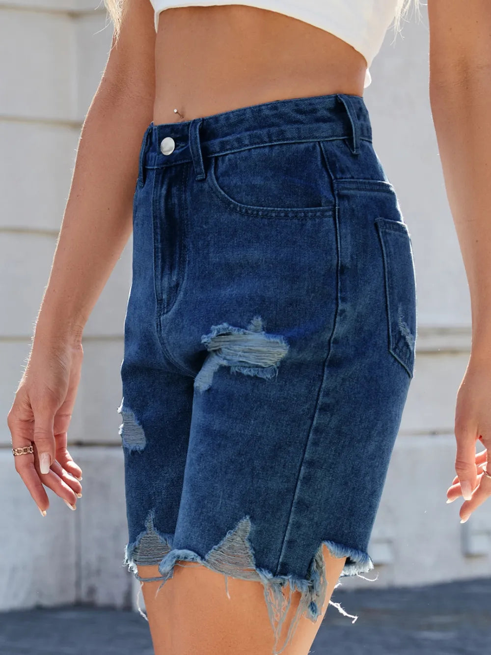 Trendsi distressed raw hem denim shorts displayed on a model, showcasing a casual, trendy summer style.