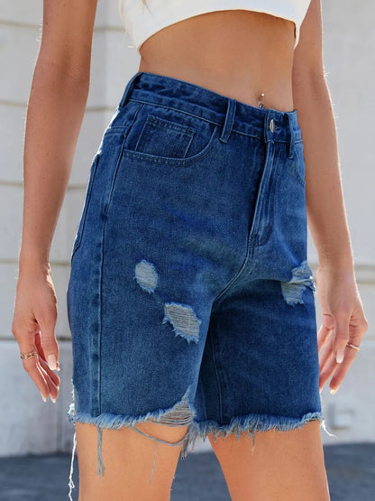 Medium wash distressed raw hem denim shorts by Trendsi, featuring frayed edges and casual fit, perfect for summer casual wear.
