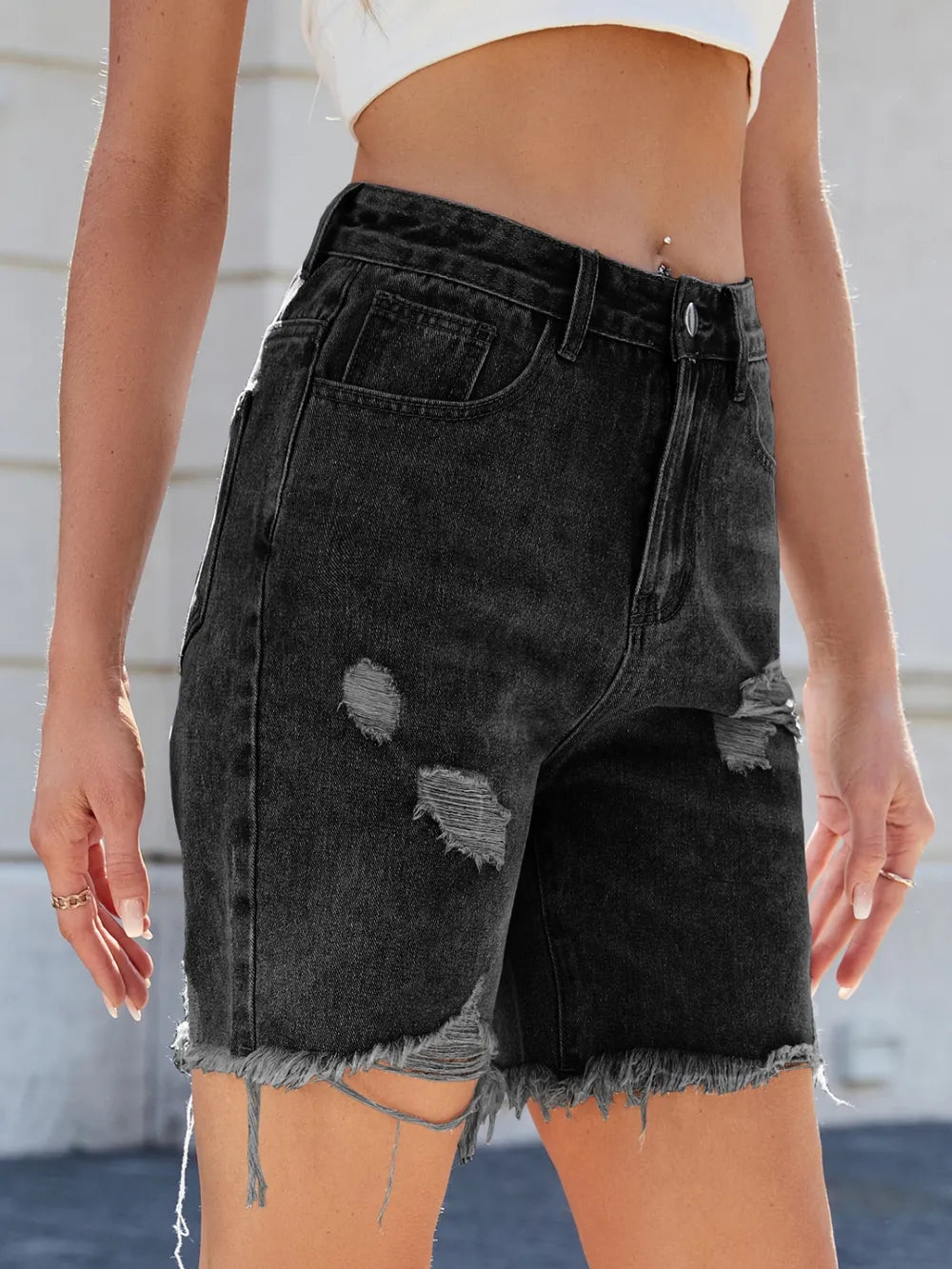 Distressed raw hem denim shorts by Trendsi, featuring frayed edges and casual fit, displayed on a model.