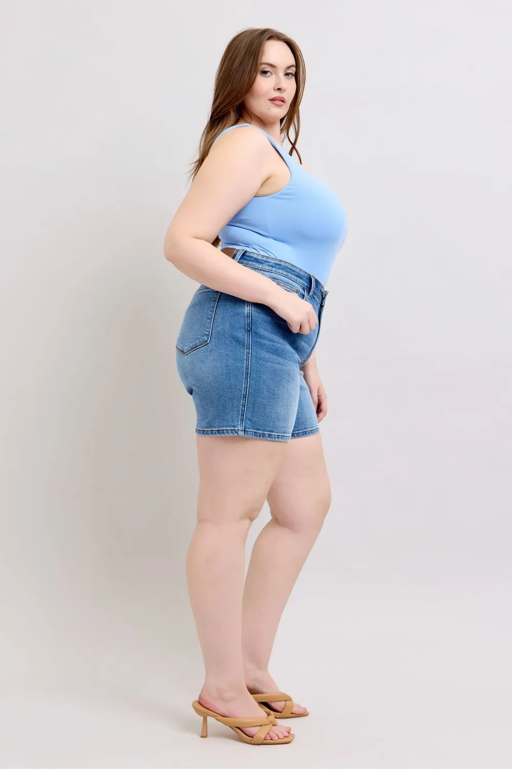 Plus size Judy Blue denim shorts with two buttons and pockets, featuring a full-size fit and trendy style.