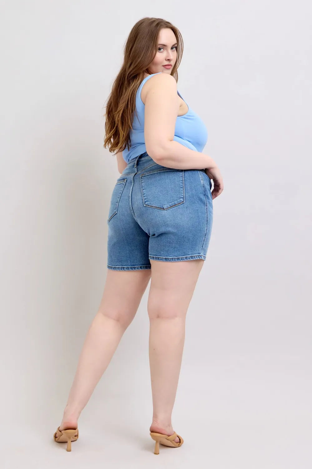 Plus size Judy Blue denim shorts with a 2-button front and pockets, featuring a full-size fit in a classic blue wash.