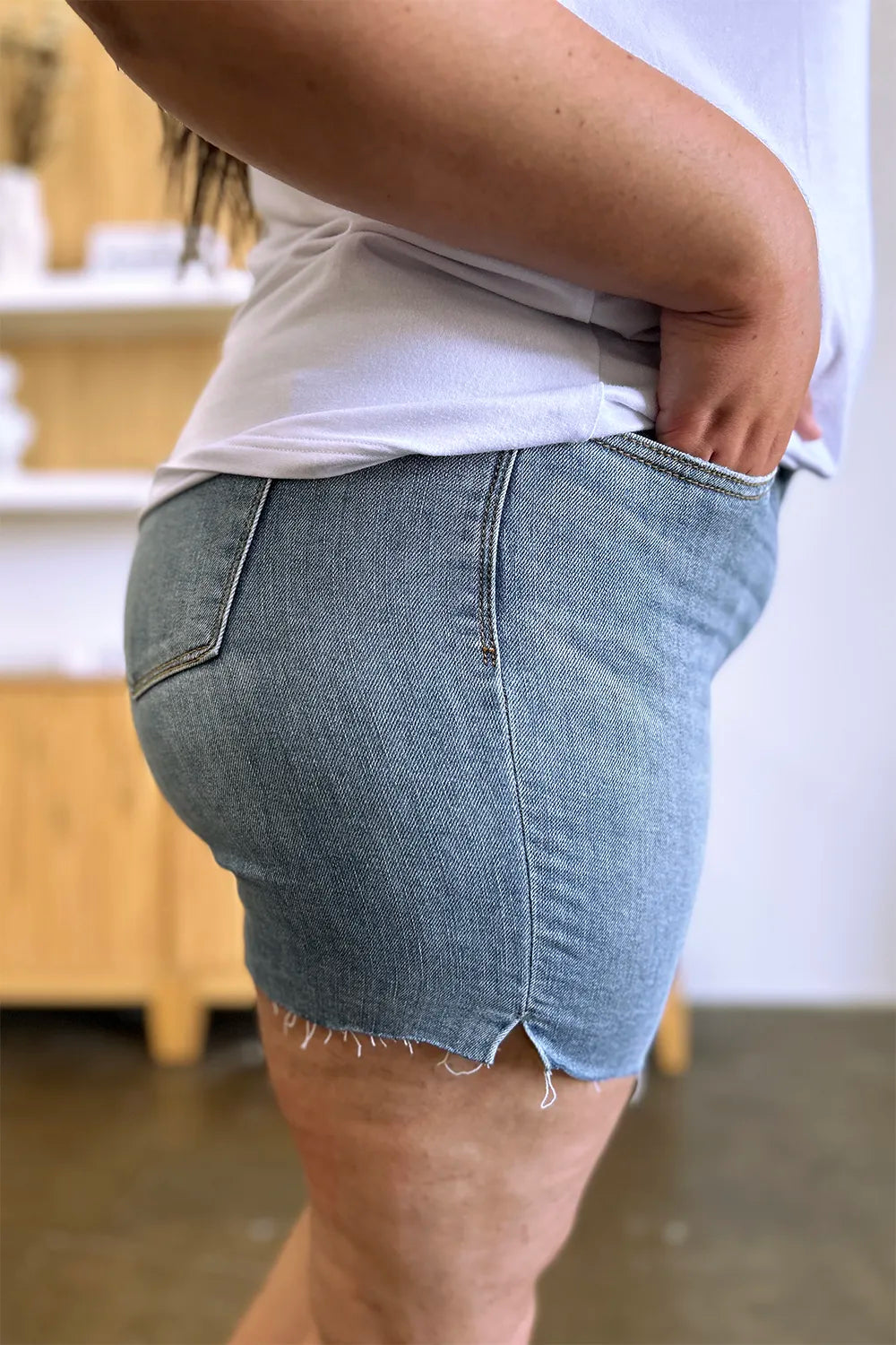 Judy Blue high waist raw hem denim shorts in medium wash, full size, showcasing distressed style and classic fit.