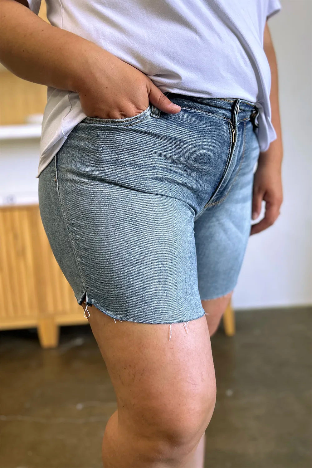 Trendsi Judy Blue high waist raw hem denim shorts in full size, featuring a classic blue wash and distressed hem detail.