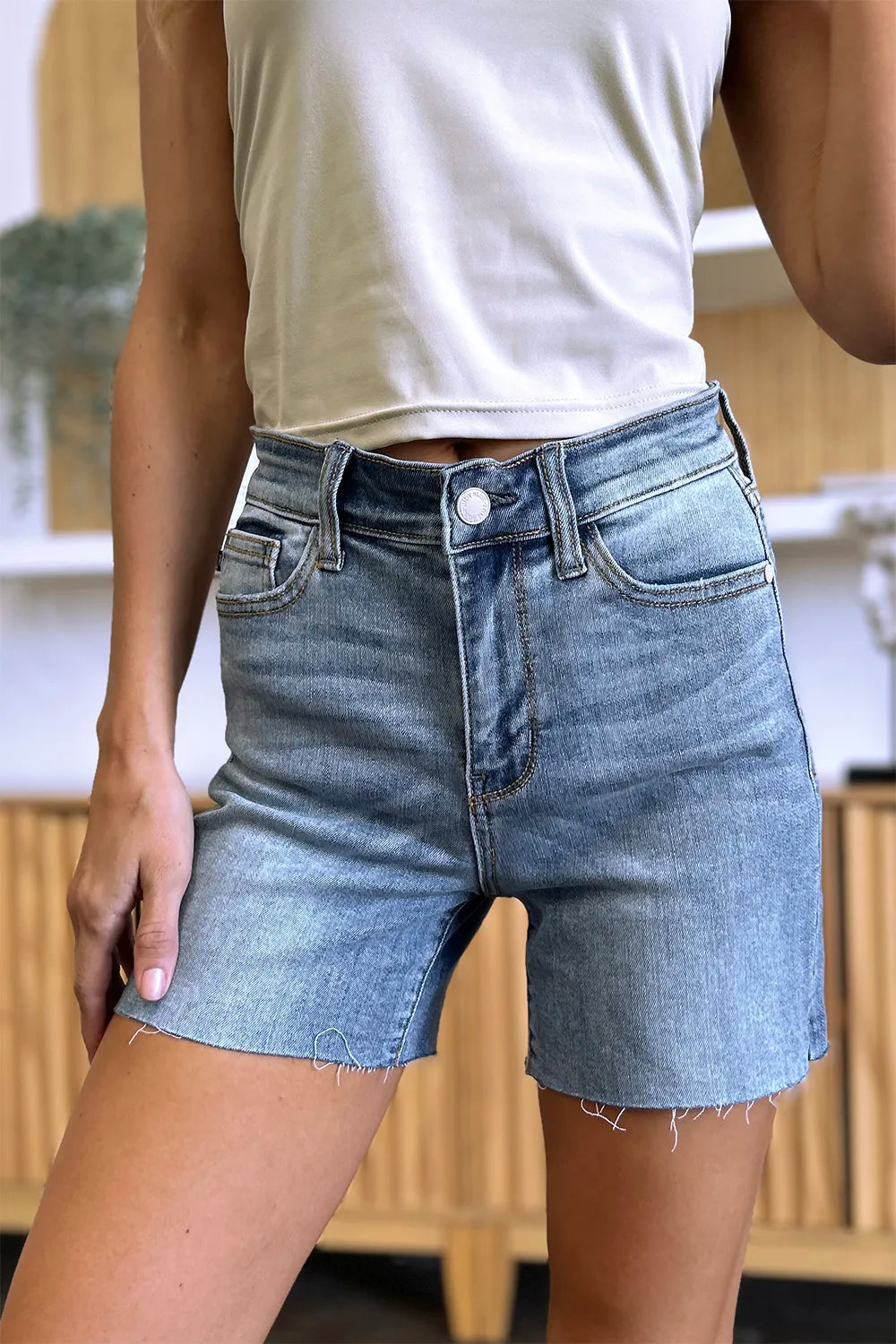 Full size Judy Blue high waist raw hem denim shorts with distressed details and classic blue wash, styled for casual summer wear.