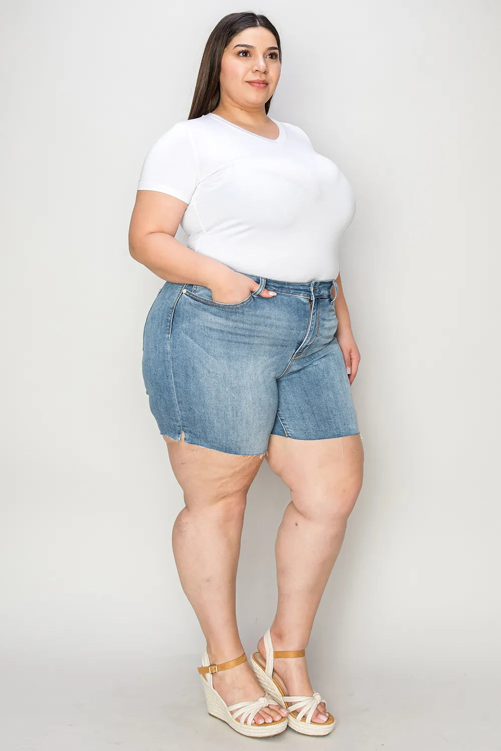 Judy Blue high waist raw hem denim shorts in full size, showcasing distressed detailing and classic blue denim fabric.