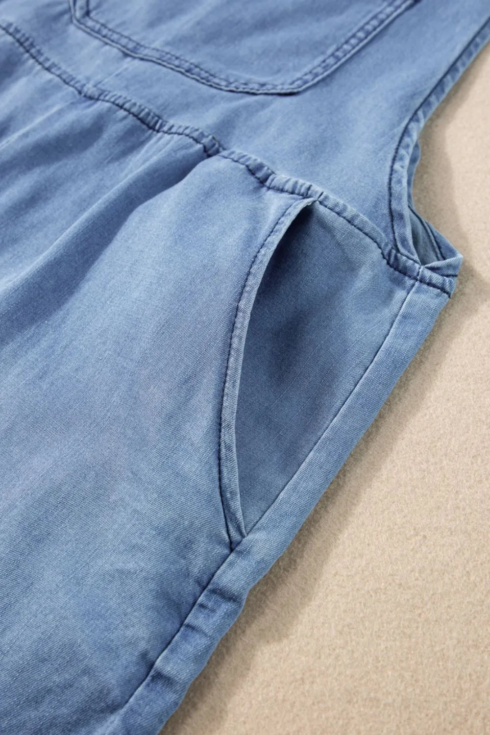 Square neck denim overalls with pockets from Trendsi, featuring a fitted design and classic blue denim fabric.