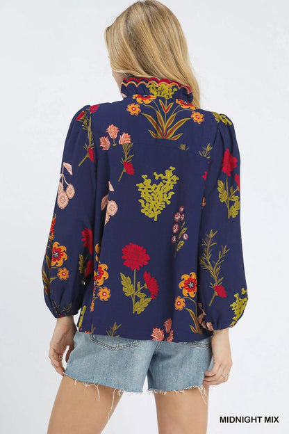 Umgee flower print blouse by Trendsi featuring a scalloped neckline and midnight mix pattern, shown on a model.