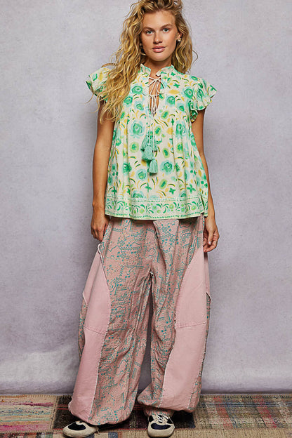Mint green floral blouse with flutter sleeves and tassel ties by Trendsi, shown with a relaxed fit and delicate floral pattern.