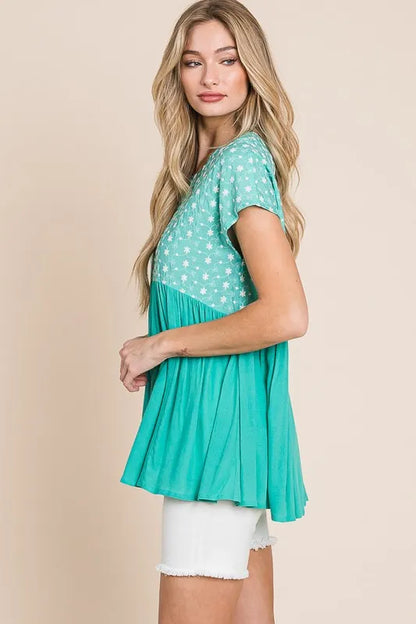 Plus size Lime 'N' Chili embroidered short sleeve pleated babydoll top by Trendsi, featuring vibrant embroidery and a flowy silhouette.