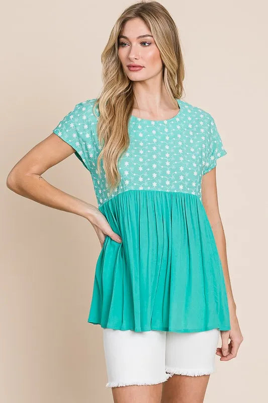 Plus size lime and chili embroidered short sleeve pleated babydoll top by Trendsi, featuring a stylish, flowy design.
