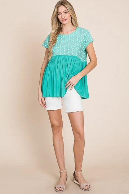 Plus size Lime 'N' Chili embroidered short sleeve pleated babydoll top by Trendsi, showing detailed embroidery and flowing pleated fabric.