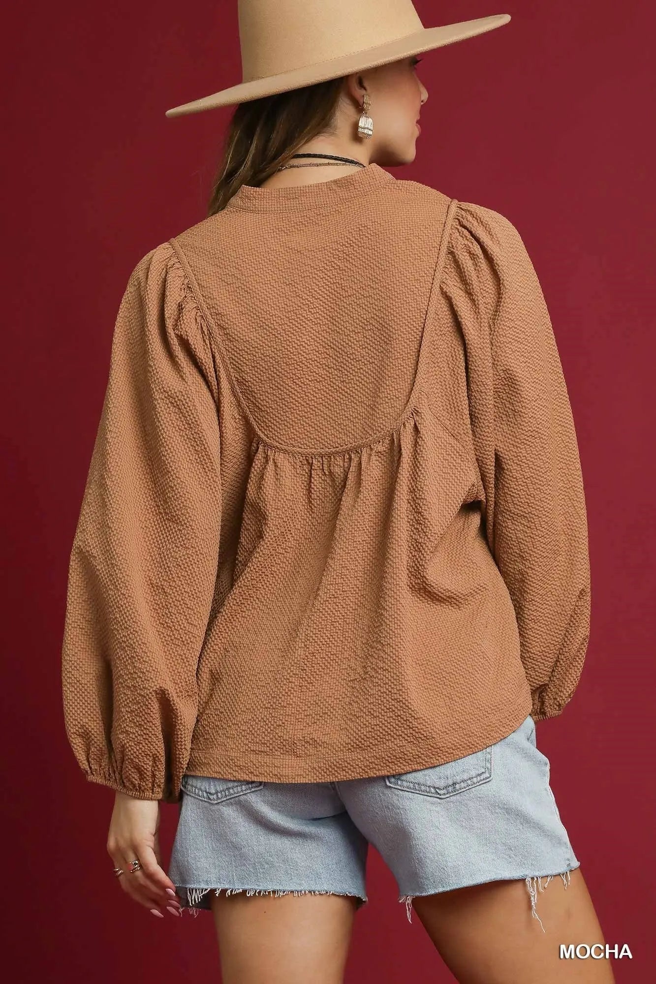Mocha Umgee textured notched blouse with balloon sleeves, shown on a model, featuring stylish design and intricate fabric details.