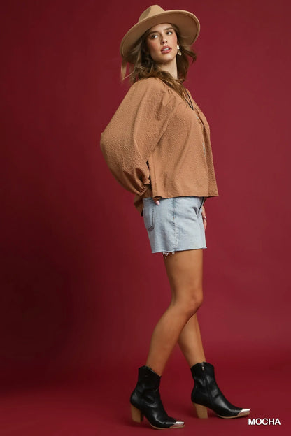 Trendsi Mocha Umgee textured notched blouse with balloon sleeves, showcasing a stylish and comfortable women's top.