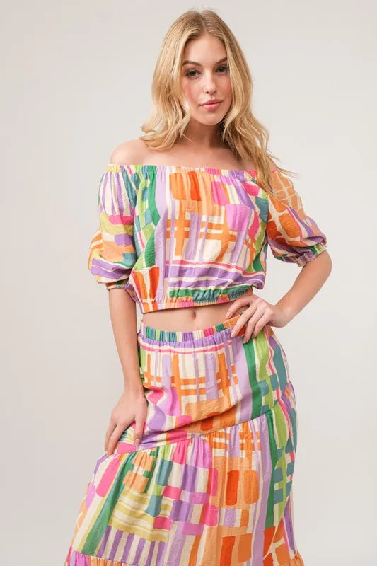 Asymmetric geo-printed tiered maxi skirt by Trendsi, featuring bold geometric patterns and flowing tiered design.