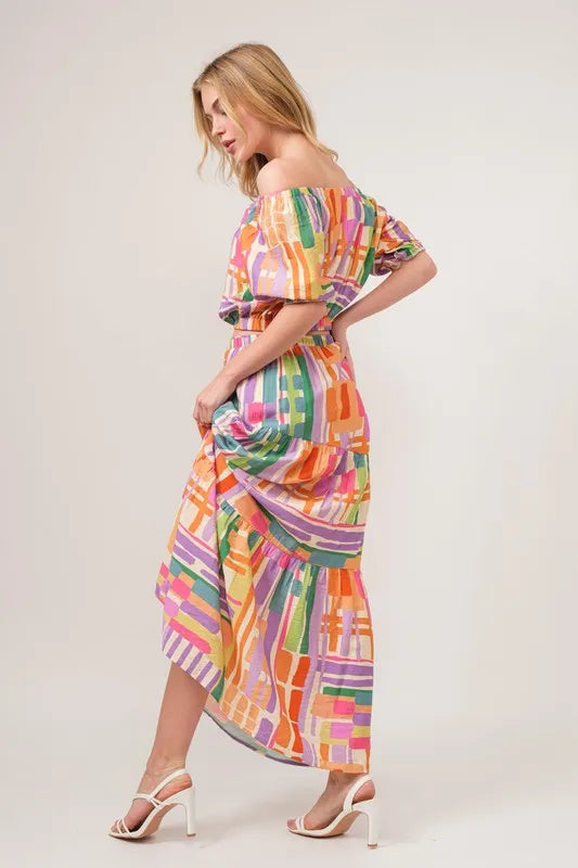 Multi-colored geometric printed asymmetric tiered maxi skirt by Trendsi, showcasing its flowing fabric and stylish design.