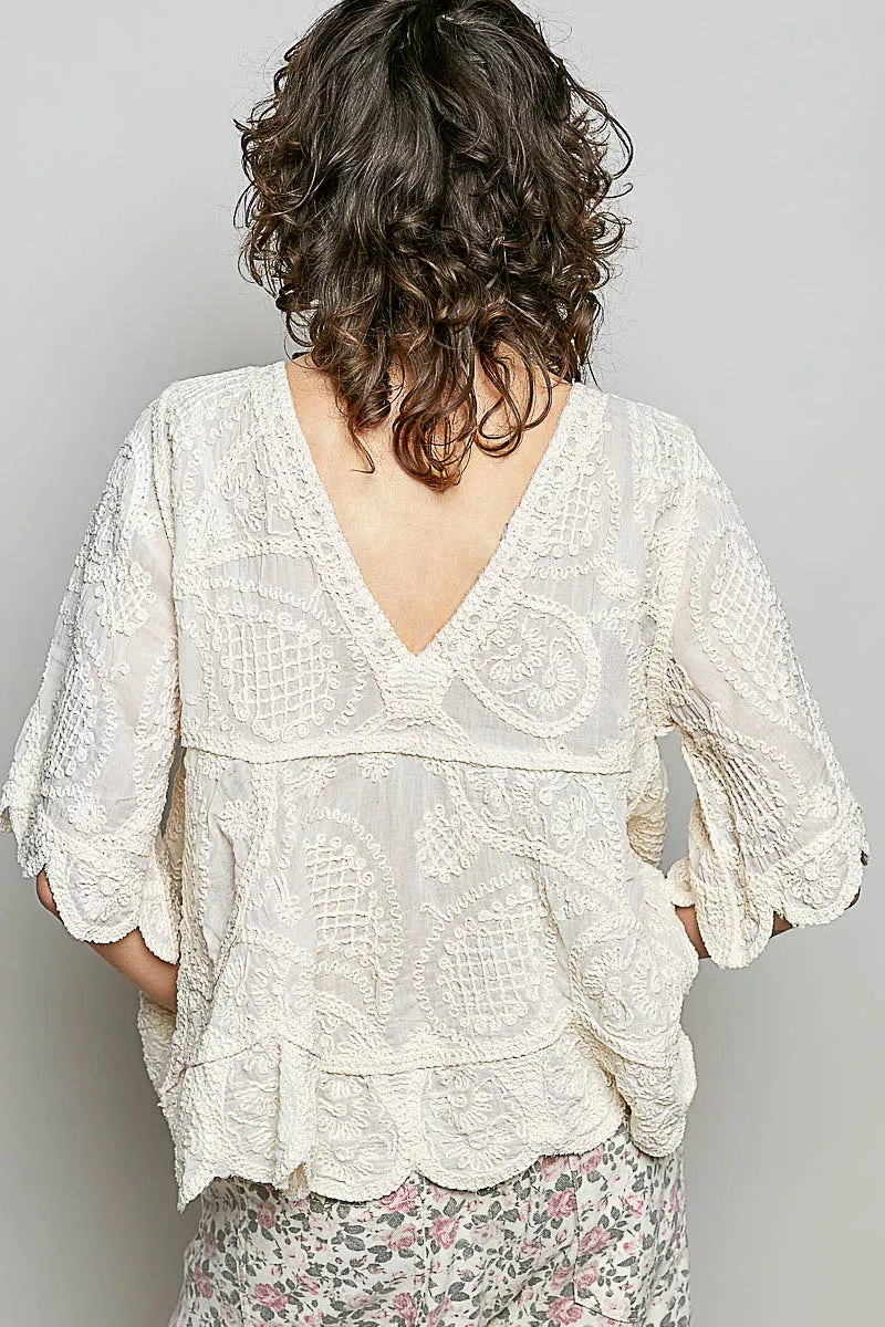 Natural V-neck crochet blouse with scalloped hem by Trendsi, featuring intricate crochet pattern and feminine design.