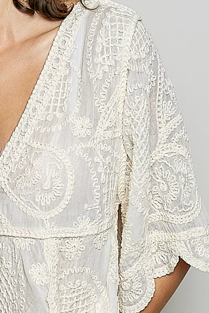 Natural V-neck crochet blouse with scalloped hem by Trendsi, featuring intricate crochet pattern and stylish feminine design.