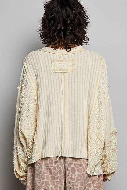 Natural V-neck long sleeve top with stitch detail from Trendsi, featuring a comfortable fit and subtle decorative stitching.