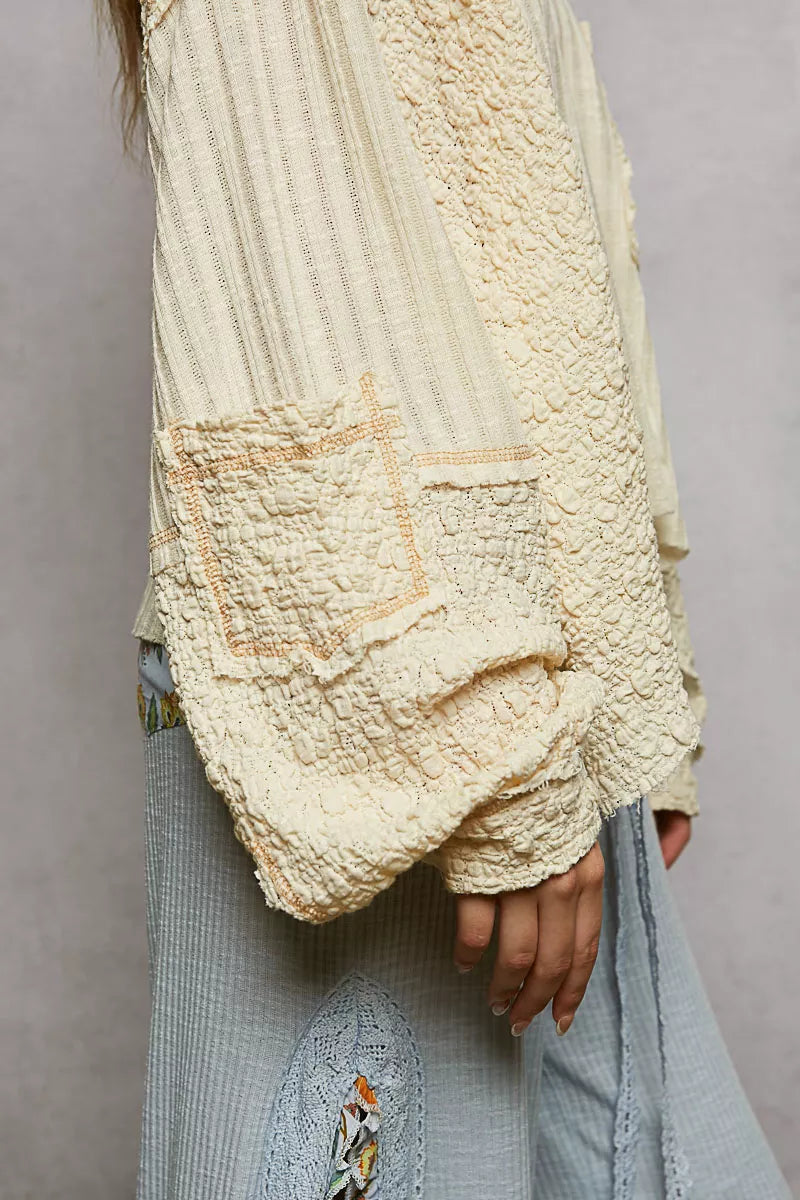 Natural V-neck long sleeve top with stitch detail by Trendsi, featuring a comfortable fit and subtle textured accents.