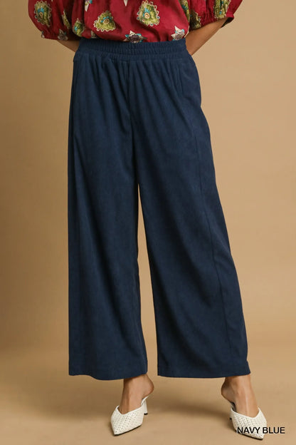 Navy blue Umgee wide-leg corduroy pants from Trendsi, featuring a relaxed fit and textured fabric, shown on a model.
