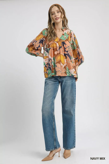 Umgee multicolor abstract floral print blouse with ruffle neckline, featuring vibrant colors and stylish design.