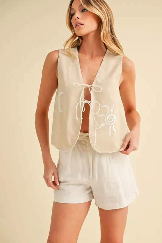 Aemi+Co embroidered tied front vest coat in oatmeal color, featuring detailed embroidery and a stylish front tie design.