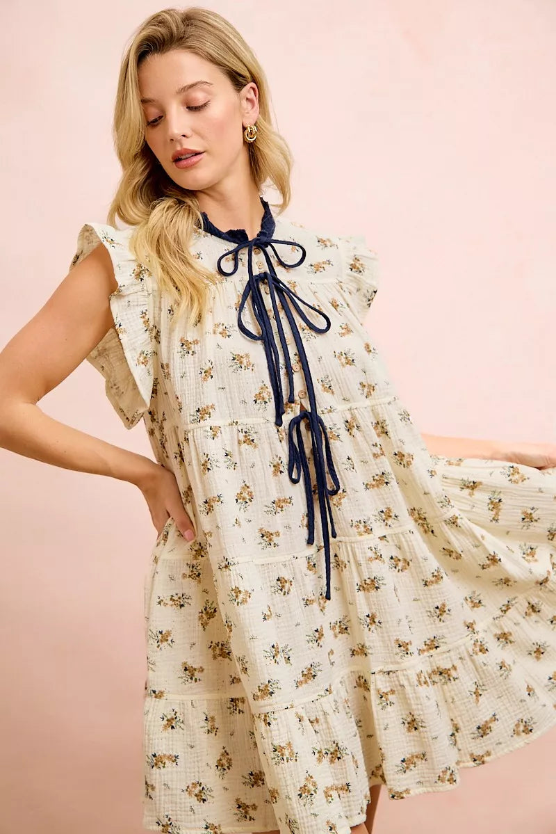 Trendsi BiBi floral multi-tiered dress in oatmeal navy with ruffles and front tie, featuring a feminine, layered design.