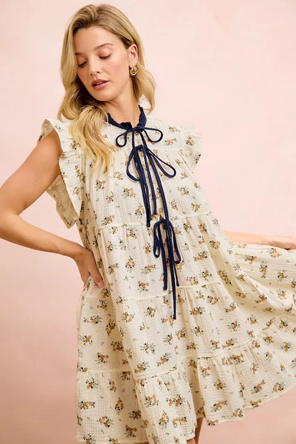 Trendsi BiBi floral multi-tiered dress in oatmeal navy with ruffles and front tie, featuring a feminine, layered design.