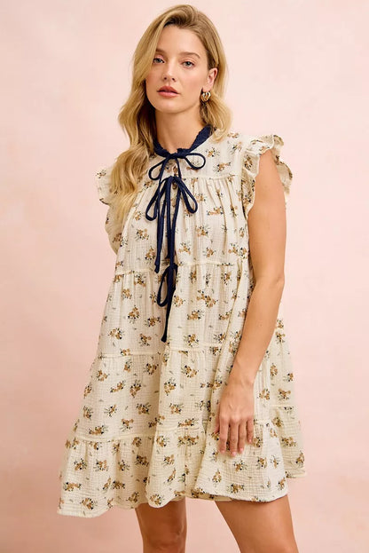 Trendsi BiBi floral multi-tiered dress in oatmeal navy with ruffles and front tie, styled for a feminine, flowy look.