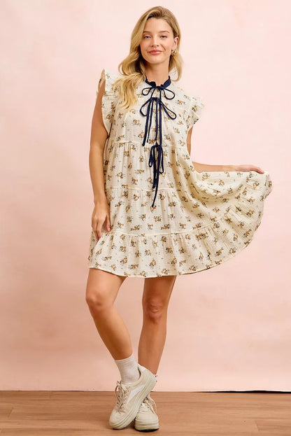 Trendsi BiBi floral multi-tiered dress in oatmeal navy with ruffles and front tie, showcasing a feminine, layered design.