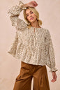 Oatmeal BiBi floral printed peplum blouse with shirring and tied details, styled with soft fabric and feminine design.