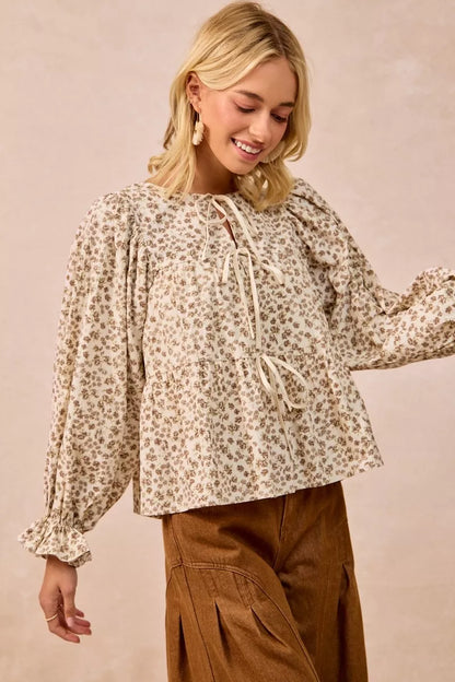 Oatmeal BiBi floral printed peplum blouse by Trendsi with shirring and tied detail, showcasing a feminine, flowy design.