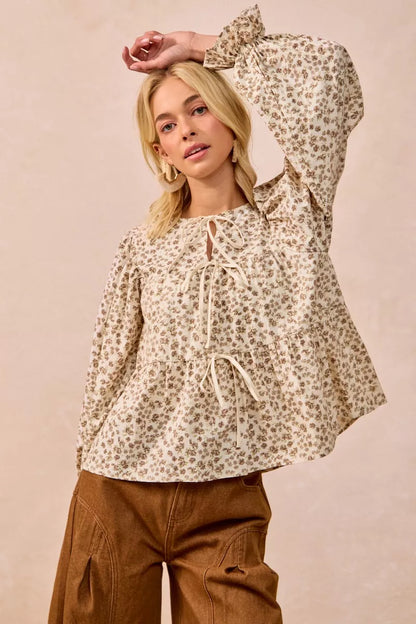 Oatmeal floral printed peplum blouse with shirring and tied detail from Trendsi, showcasing a stylish, feminine design.