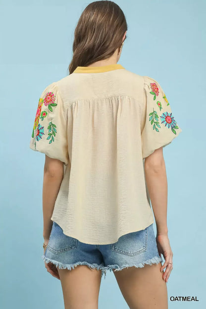Oatmeal Umgee embroidered puff sleeve top with intricate embroidery and ruffled cuffs, styled on a mannequin.