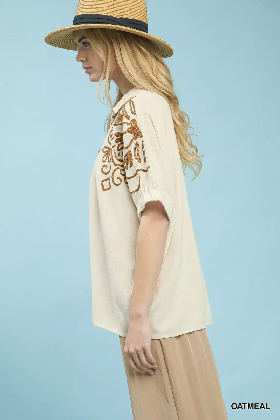 Oatmeal floral embroidered sleeve blouse by Umgee, featuring delicate embroidery and stylish design, displayed on a hanger.