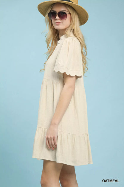 Oatmeal linen tiered babydoll dress with scalloped sleeves by Umgee, featuring a relaxed fit and feminine design.