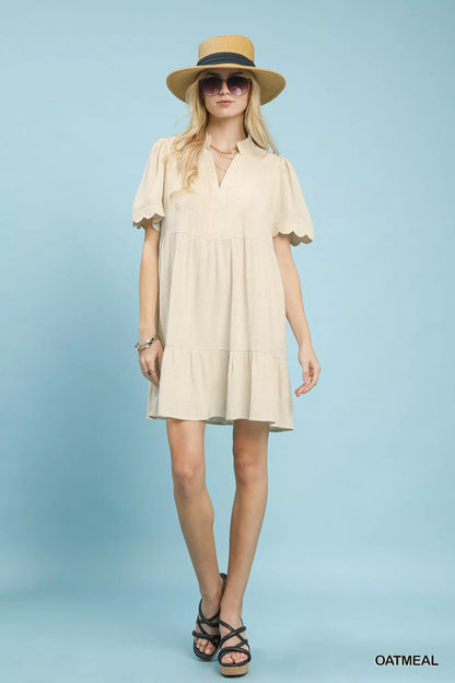 Oatmeal linen tiered babydoll dress with scalloped sleeves by Umgee, featuring a relaxed fit and feminine design.