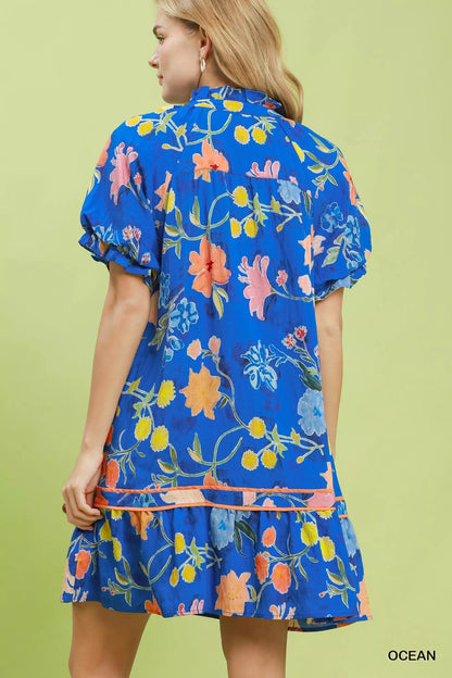 Umgee floral ruffle hem mini dress from Trendsi, featuring a vibrant floral pattern and ruffle details on the hem.
