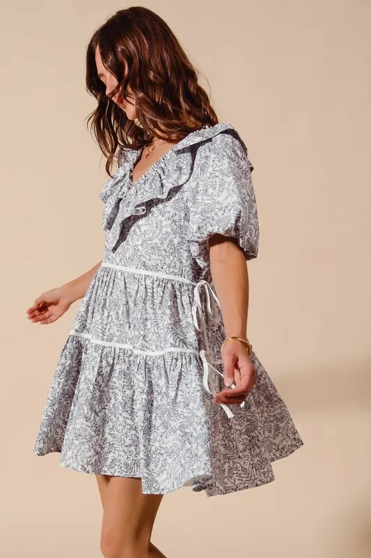 Off-white navy cotton printed ruffle V-neckline dress with side tie by Trendsi, showcasing elegant ruffle details and a flattering fit.