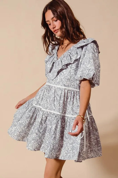 Off-white and navy cotton printed ruffle V-neckline dress with side tie from Trendsi, showcasing a stylish and feminine design.