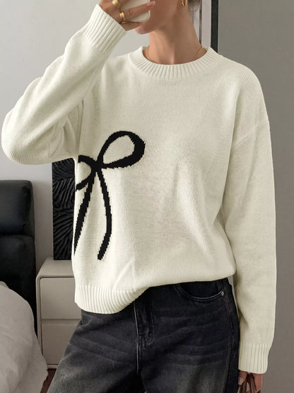 Off-white Bow Graphic Round Neck Sweater by Trendsi, featuring a playful bow print on a cozy knit fabric.