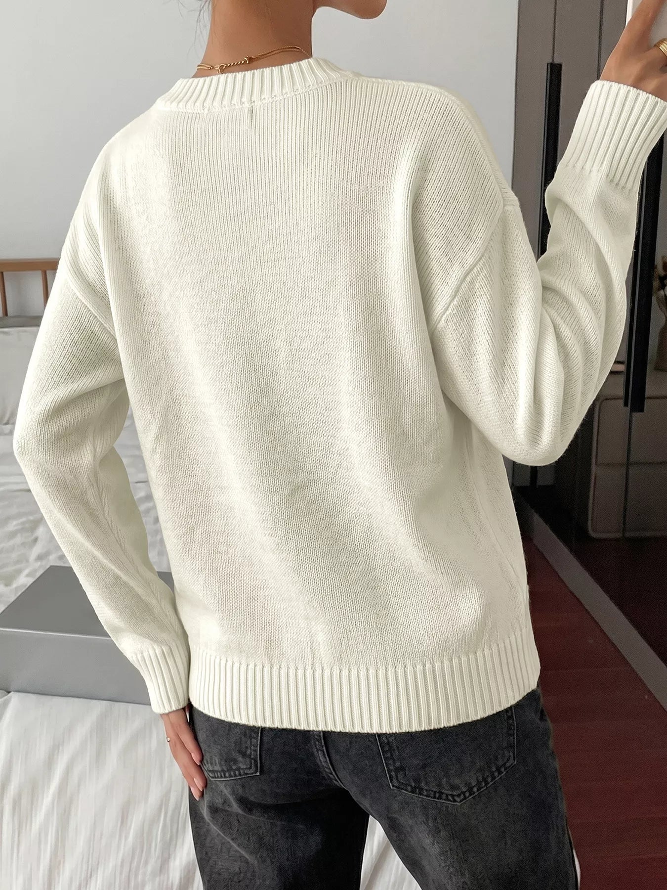 Off-white bow graphic round neck sweater from Trendsi, featuring a stylish design and cozy fit.