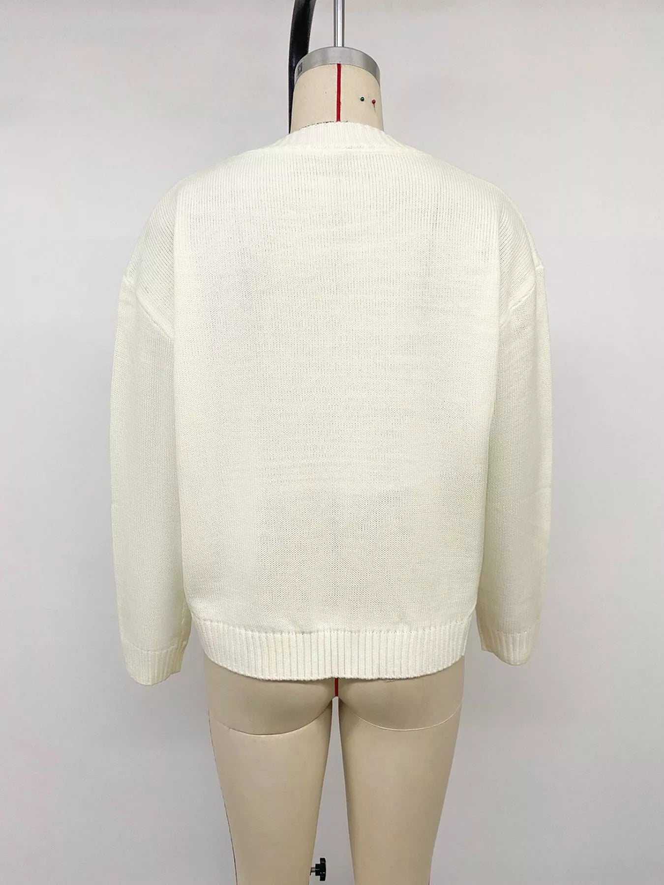 Off-white Bow Graphic Round Neck Sweater by Trendsi, featuring a cute bow graphic design on a cozy knit fabric.