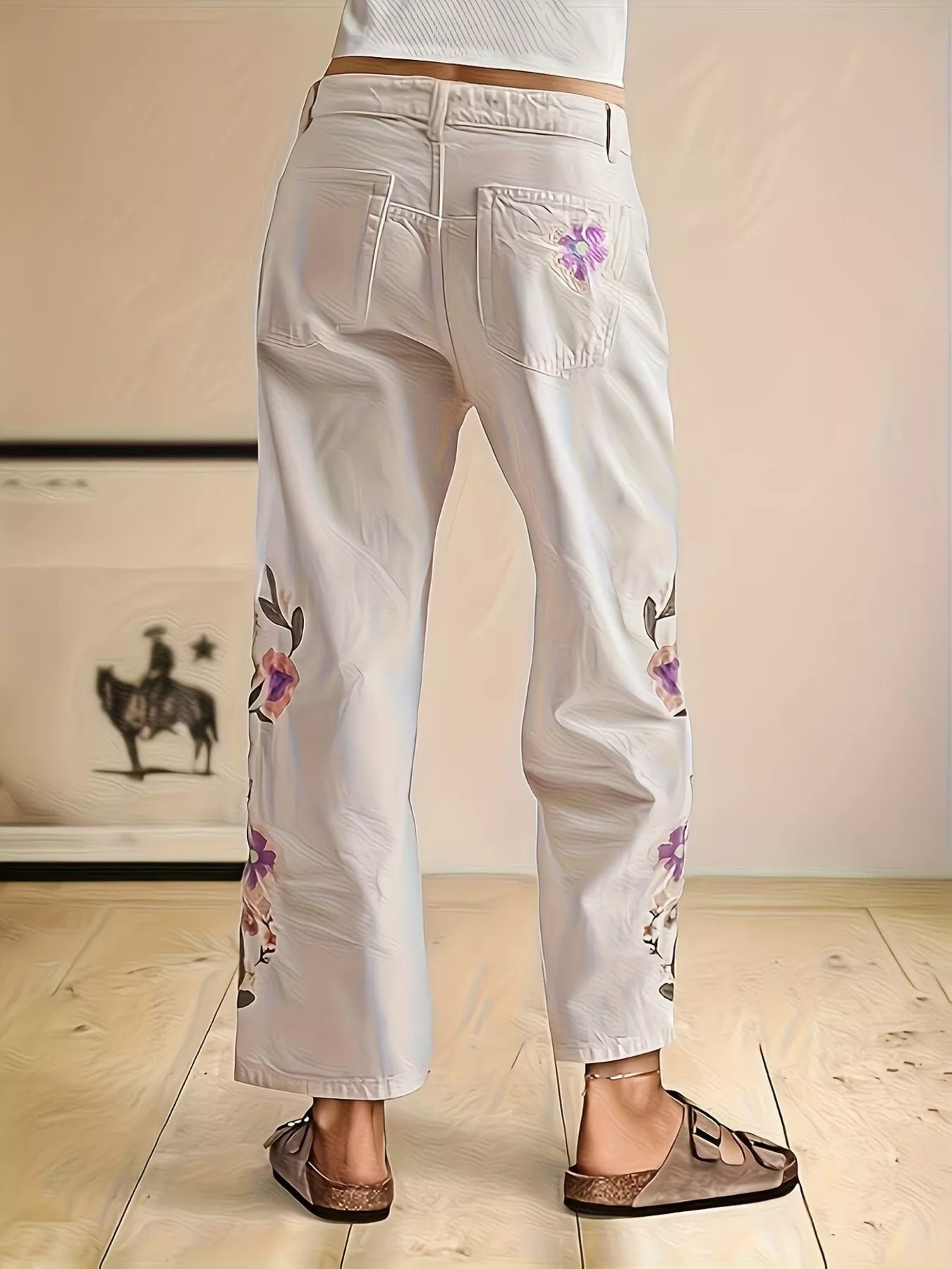 Off-white embroidered floral wide-leg jeans by Trendsi featuring detailed floral embroidery and a relaxed wide-leg fit.