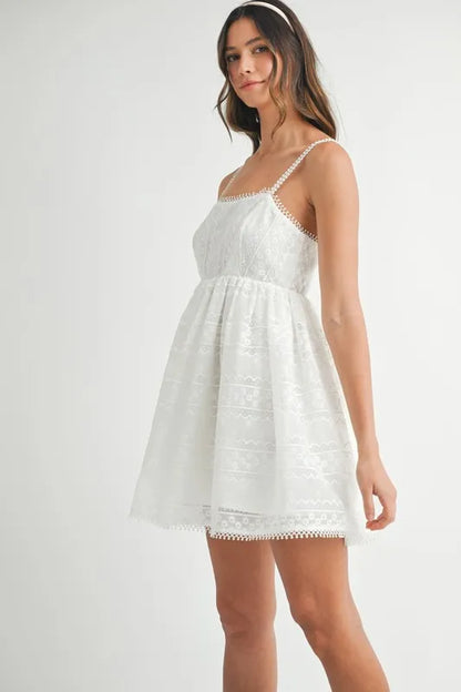 Off-white MABLE eyelet lace babydoll mini cami dress by Trendsi, featuring delicate lace details and a flattering fit.