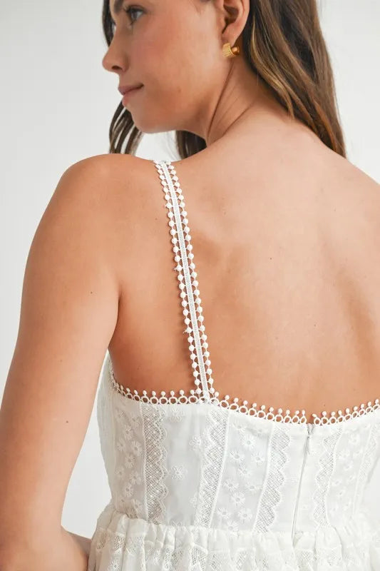 Off-white MABLE Eyelet Lace Babydoll Mini Cami Dress by Trendsi, featuring delicate eyelet lace and a flowy, feminine silhouette.