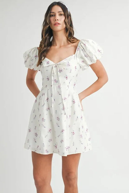 Off-white MABLE floral print puff sleeve mini dress by Trendsi, featuring a fitted bodice and short puff sleeves.
